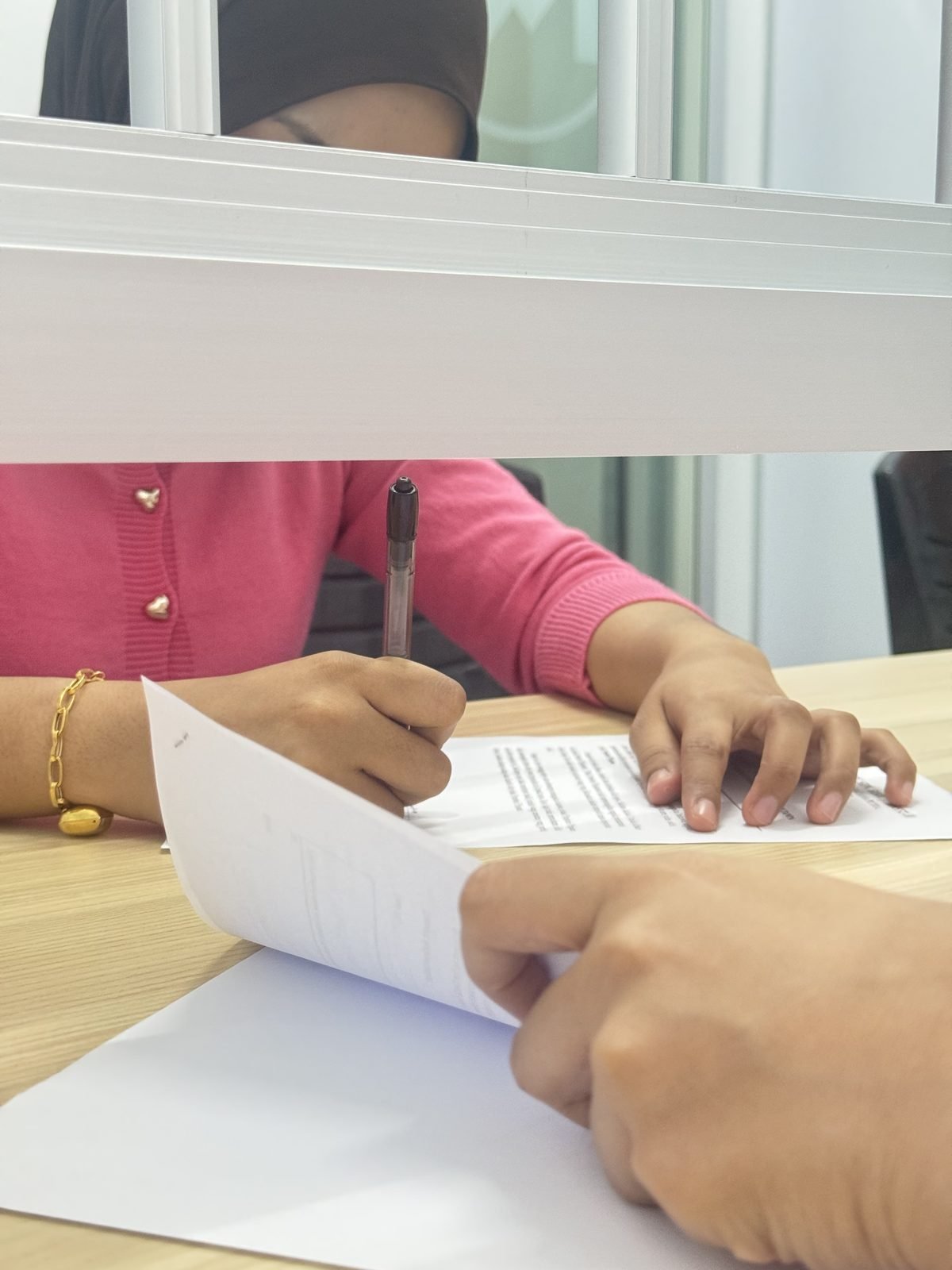 A Metro Cashe Management officer explaining a loan agreement to a customer at the counter