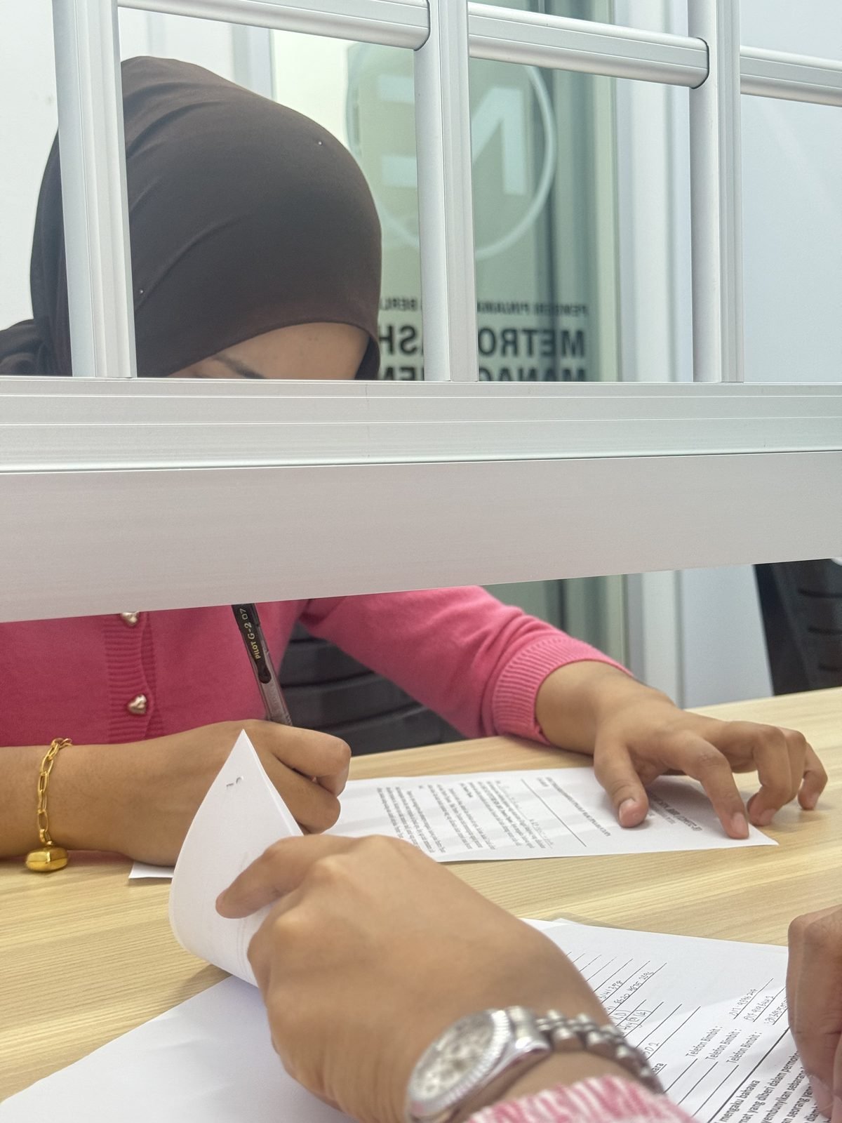 A customer signing a loan agreement at the office counter